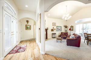 Entrance foyer featuring a chandelier, light hardwood / wood-style flooring, and lofted ceiling