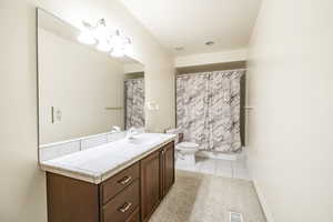 Bathroom featuring tile patterned flooring, vanity, and toilet