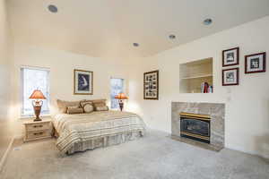 Bedroom with carpet flooring and a fireplace