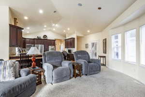 Living room with light carpet and vaulted ceiling