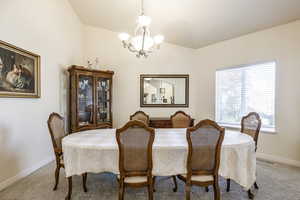 Carpeted dining room featuring a chandelier