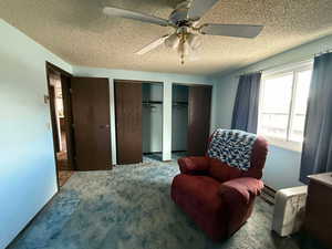 Sitting room featuring ceiling fan, carpet floors, and a textured ceiling