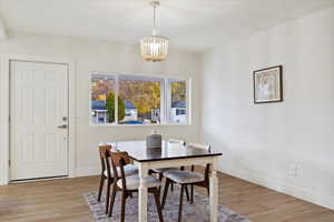 Dining space with light hardwood / wood-style flooring and a chandelier