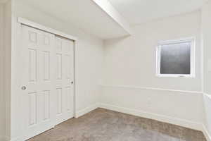 Unfurnished bedroom featuring light colored carpet and a closet