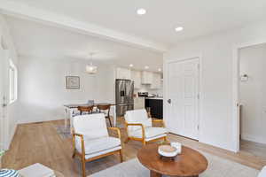 Living room featuring an inviting chandelier and light hardwood / wood-style flooring