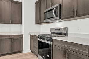 Kitchen with dark brown cabinets and stainless steel appliances