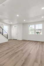 Interior space featuring a textured ceiling and light hardwood / wood-style floors