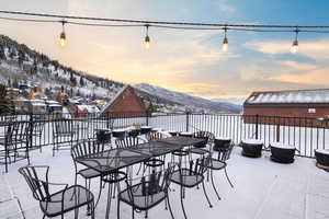 Snow covered patio with a mountain view