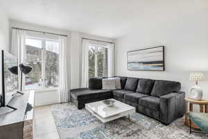 Living room with a wealth of natural light, light hardwood / wood-style flooring, and a textured ceiling