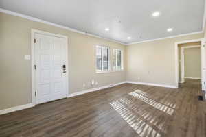 Spare room featuring crown molding and dark hardwood / wood-style flooring