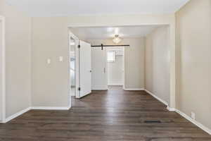 Master Bedroom View 3 with a barn door and dark hardwood / wood-style floors