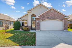 View of front of home featuring central AC, a front yard, and a garage