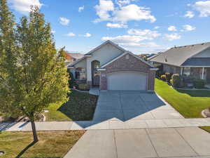 Ranch-style home with a front lawn and a garage