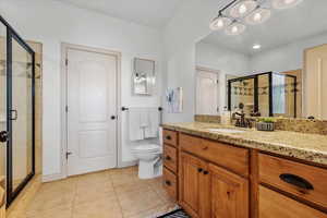 Bathroom featuring tile patterned floors, a shower with door, and toilet