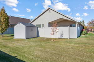 Back of property featuring a yard and a shed