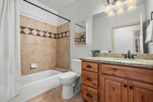 Full bathroom featuring toilet, vanity, tile patterned floors, and shower / bathtub combination with curtain