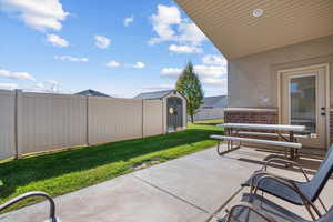 View of patio featuring a storage shed