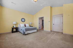 Carpeted bedroom with lofted ceiling