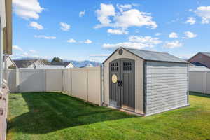 View of outbuilding featuring a mountain view and a lawn