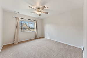 Carpeted spare room with ceiling fan