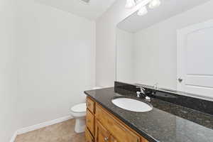 Bathroom with tile patterned flooring, vanity, and toilet