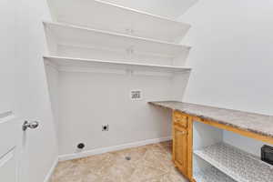 Laundry room featuring hookup for an electric dryer, hookup for a washing machine, and light tile patterned flooring