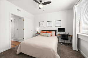 Bedroom with dark colored carpet and ceiling fan