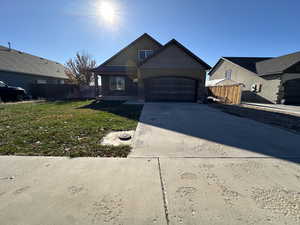 View of front of property with a garage and a front lawn