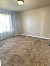 Spare room featuring carpet and a textured ceiling