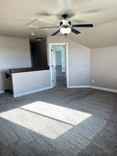 Carpeted empty room featuring ceiling fan, lofted ceiling, and a textured ceiling