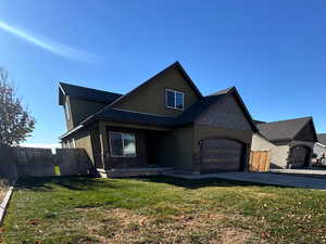 View of front of property featuring a garage and a front lawn