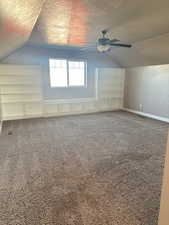 Additional living space with carpet, a textured ceiling, ceiling fan, and lofted ceiling