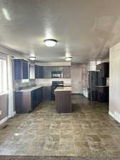 Kitchen featuring light stone countertops, dark brown cabinets, a textured ceiling, sink, and black appliances