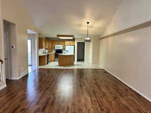 Unfurnished living room featuring sink, high vaulted ceiling, and light hardwood / wood-style flooring