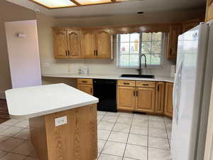 Kitchen featuring dishwasher, white refrigerator with ice dispenser, light tile patterned flooring, and sink