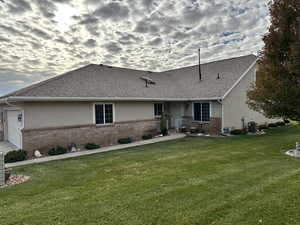 Ranch-style house featuring a lawn, cooling unit, and a garage