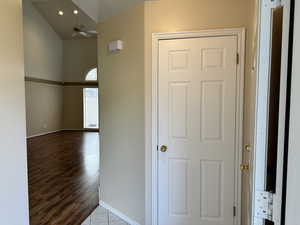 Corridor with light hardwood / wood-style floors, lofted ceiling, and a textured ceiling