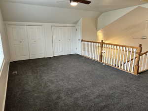 Additional living space featuring carpet, a textured ceiling, vaulted ceiling, and ceiling fan