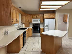 Kitchen featuring light tile patterned flooring, white appliances, and sink