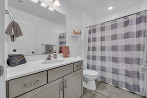 Bathroom with hardwood / wood-style floors, vanity, a shower with shower curtain, and toilet