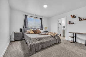 Carpeted bedroom featuring ensuite bath