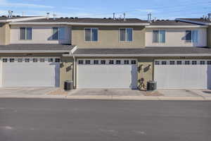 Multi unit property featuring central AC unit and a garage