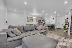 Living room with a chandelier, sink, and light hardwood / wood-style flooring