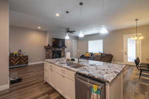 Kitchen featuring white cabinets, sink, stainless steel dishwasher, dark hardwood / wood-style floors, and decorative light fixtures