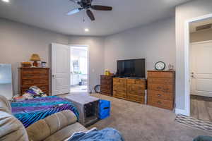 Bedroom featuring carpet, ceiling fan, and ensuite bath