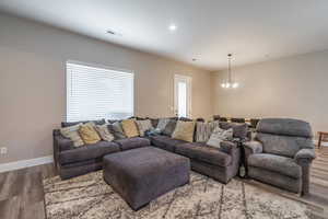 Living room with a chandelier and wood-type flooring