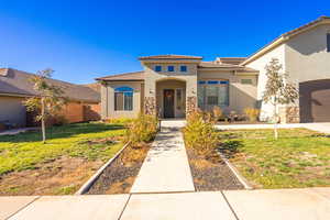 View of front of property with a front yard and a garage