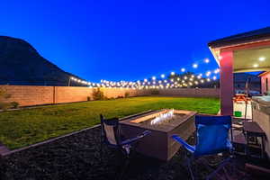 Yard at night featuring a fire pit