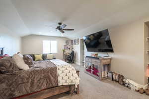 Bedroom with ceiling fan, light colored carpet, and lofted ceiling