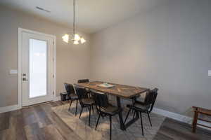 Dining space featuring dark wood-type flooring and a chandelier